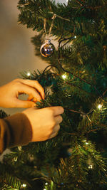 Children at home hang decorations on the christmas tree before the holiday