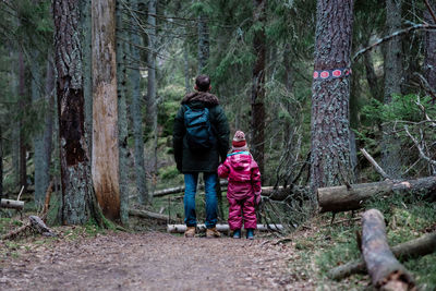 Father and daughter standing in a forest together whilst hiking