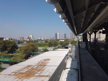 Road amidst buildings in city against clear sky