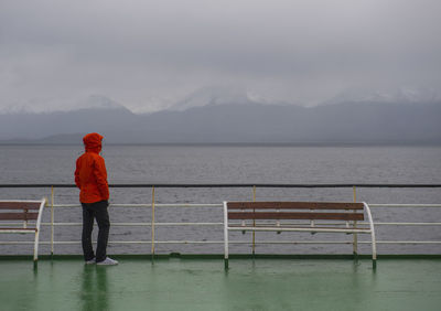 Woman looking at grim scenery from passenger vessel in patagonia