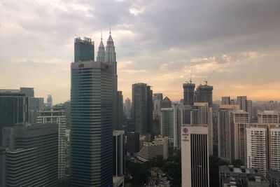 Buildings in city against cloudy sky