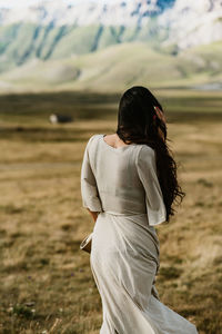 Side view of young woman standing on field