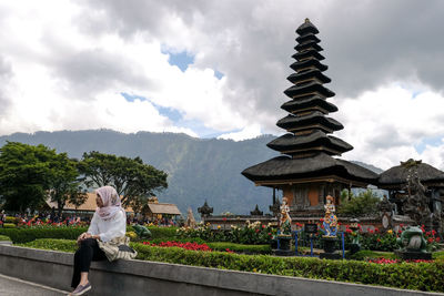 Woman with temple against sky