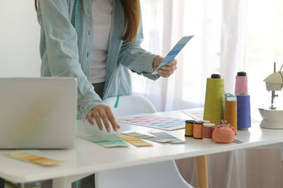 Female designers use pastel colors to design clothes in their workshops.