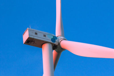 Low angle view of security camera against clear blue sky