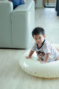 Portrait of boy sitting on floor at home