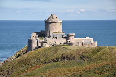 Castle by sea against sky