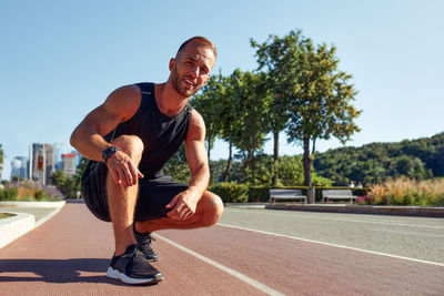 Portrait of young man exercising on road