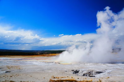 Steam emitting from hot springs against sky