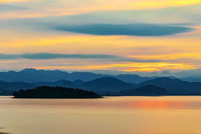 Scenic view of silhouette mountains against romantic sky at sunset