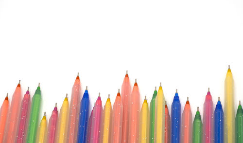 Close-up of multi colored pencils against white background