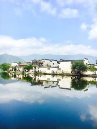 Reflection of buildings in city against sky