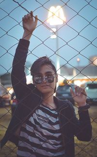 Portrait of smiling man standing by fence