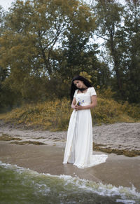 Full length of woman standing by tree