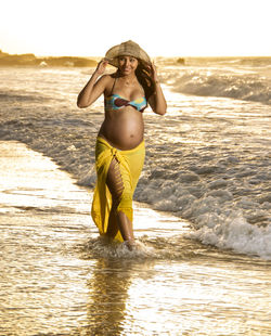 Side view of woman standing at beach