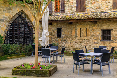 Empty chairs and tables in yard