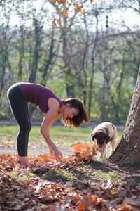 Full length of woman with dog standing in park