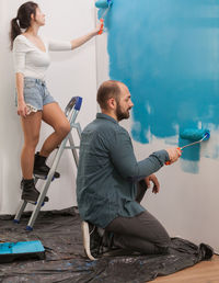 Couple painting wall at home