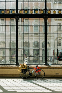 Bicycle parked in front of big glass window