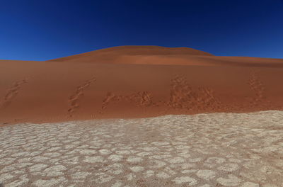 Scenic view of desert against blue sky