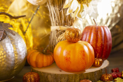 Pumpkins, glitter leaves, silver pumpkin, and dried sunflowers against a golden background