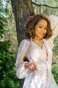 Close-up of woman with hand in tree