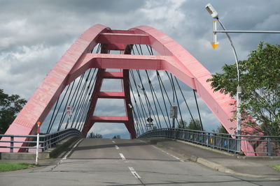 Bridge over road amidst buildings against sky