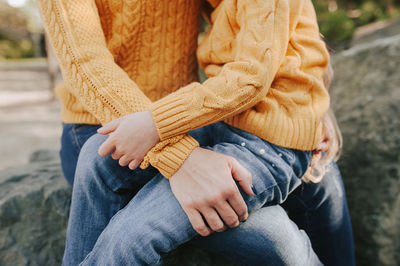 Gentle hug of parent and child dressed the same. warm autumn yellow sweater