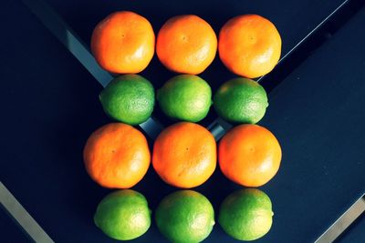 Directly above shot of limes and oranges arranged on table