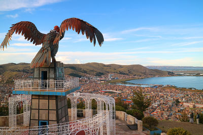 View of lake titicaca and city of puno from the condor hill with a huge condor sculpture, puno, peru
