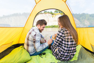 Young couple sitting at tent