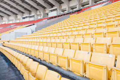 Empty orange and yellow seats at stadium,rows walkway of seat on a soccer stadium