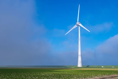 Windmill on field against sky