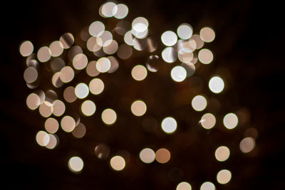 Defocused image of illuminated christmas lights at night