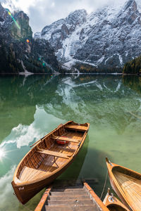 High angle view of wooden boats moored in lake by mountain