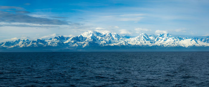 Scenic view of sea and mountains against sky