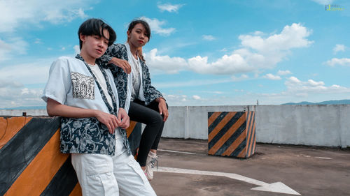 Young couple standing against sky