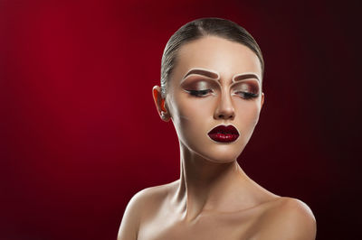 Portrait of a young woman against red background