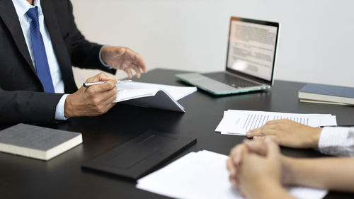 Midsection of business colleagues working on table