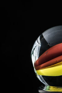 Close-up of multi colored candies in bowl against black background