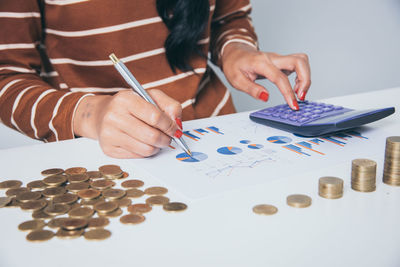 Midsection of woman holding paper with text on table