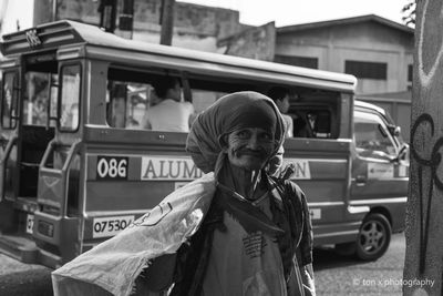 Portrait of man standing on street in city