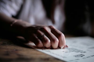 Close-up of woman reading book on table