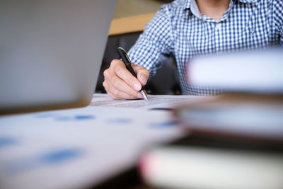 Cropped image of businessman working at desk