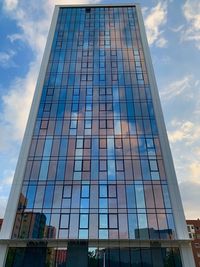 Low angle view of glass building against sky