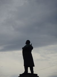 Low angle view of silhouette man standing against sky