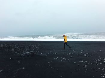 Full length of woman on beach against sky