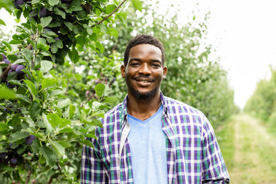 Portrait of a smiling young man against plants