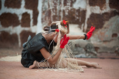 Woman with plants dancing on footpath