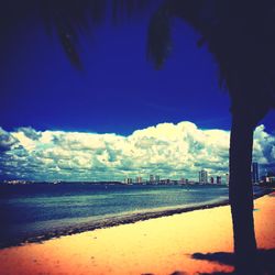 Scenic view of beach against cloudy sky